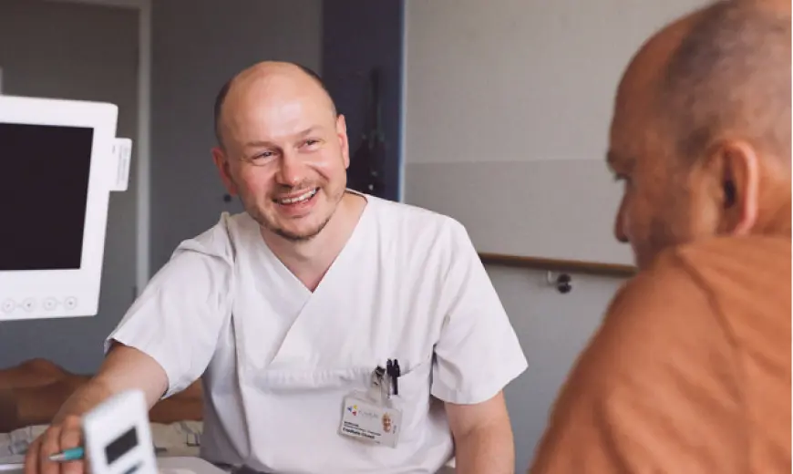 Pfleger spricht mit Patient über seine Parkinsonerkrankung